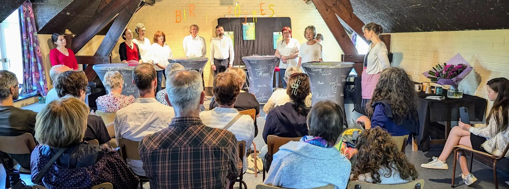 Atelier de philosophie pratique à Bruxelles : un intervenant anime une séance devant un groupe de participants attentifs.